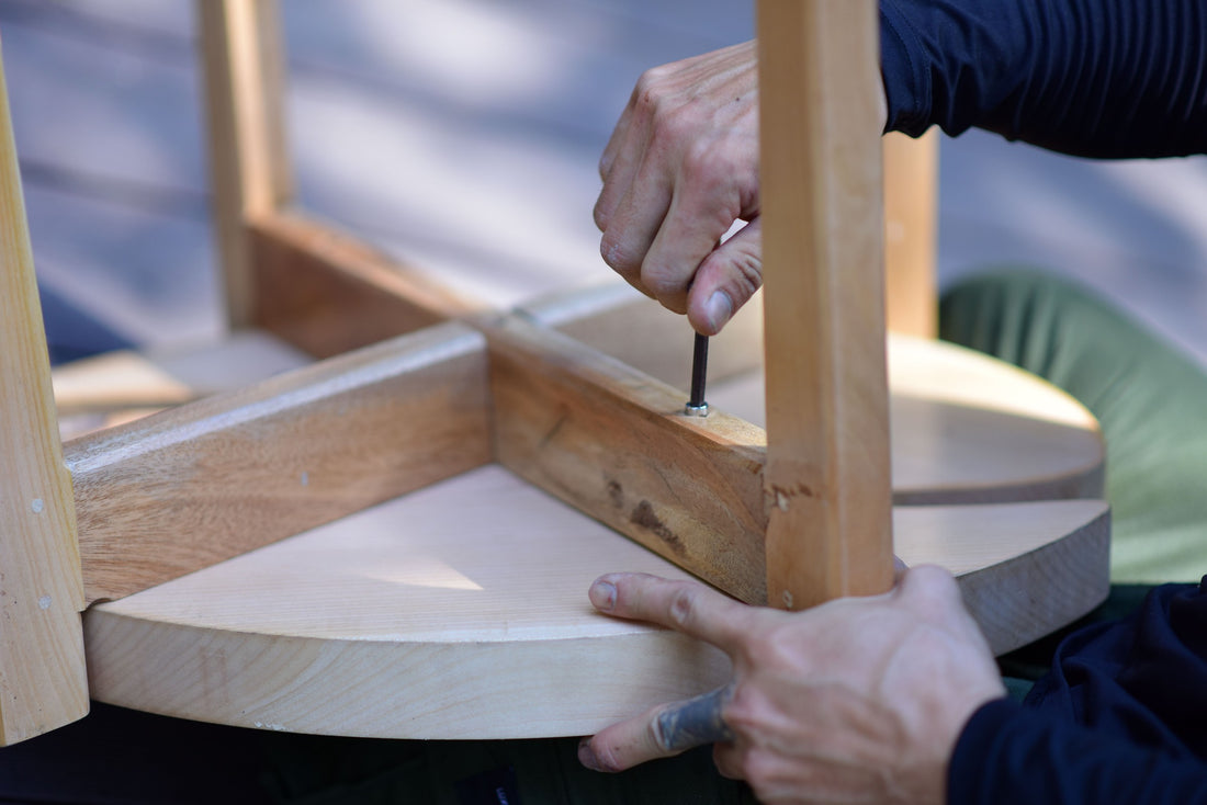 Close-up of hands fitting and securing wooden pieces together during assembly