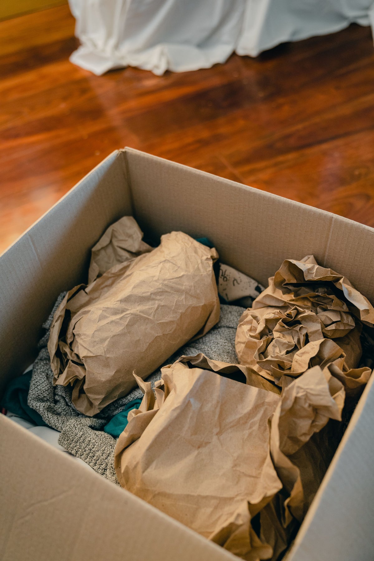 Delicate items carefully wrapped in paper and packed inside a cardboard storage box