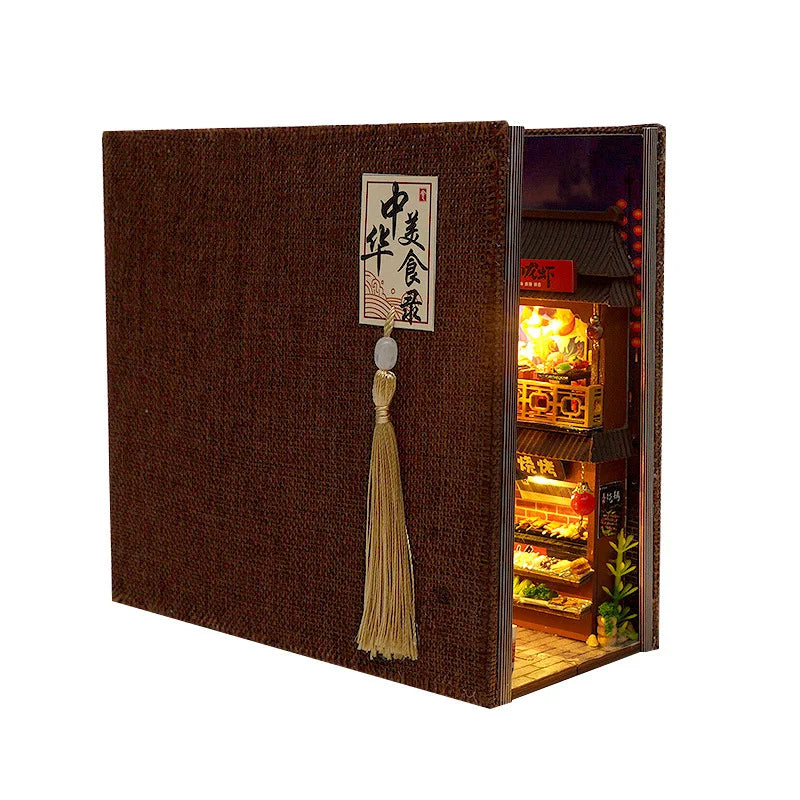 Night market street book nook kit displayed closed on a shelf between books