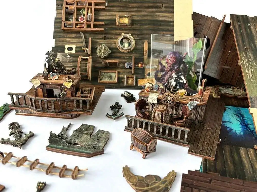 Pirate ship book nook pieces laid out during assembly: deck, railings, barrels and figures