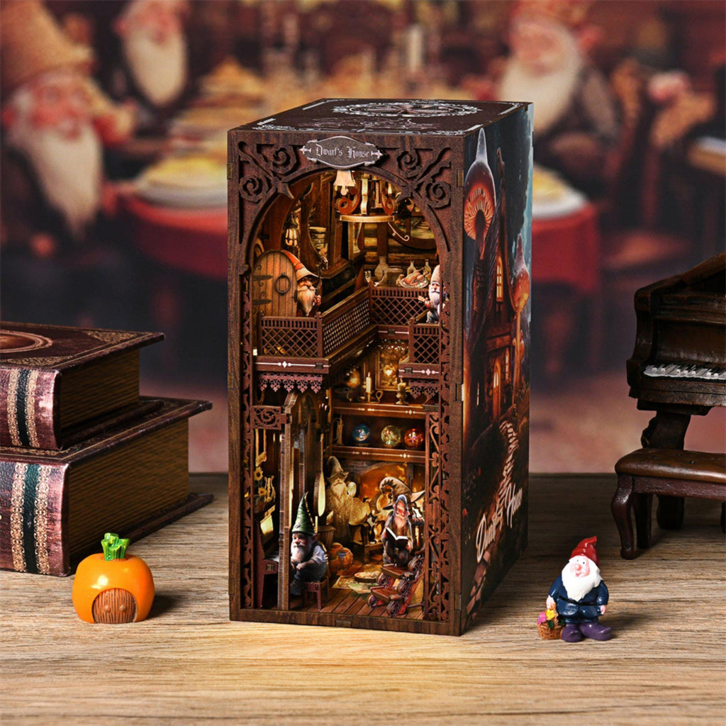 Snow White Book Nook DIY Kit shaped like an antique book, showing the Dwarfs House interior with gnome figures on the balcony